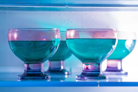 purple dishes with green woodruff jelly in a fridge