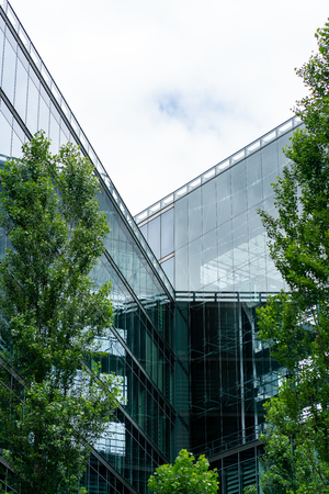 Kemper Platz, Berlin, Germany - july 07, 2019:  modern glass facade of an office building near Sony center in contrast with green trees in the foregroundのeditorial素材