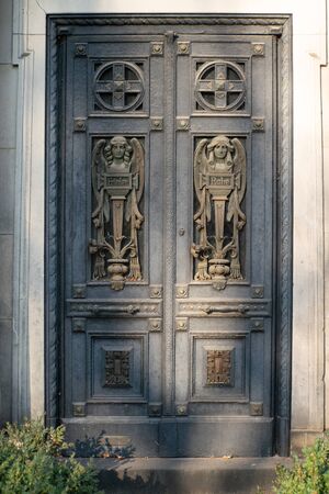 Old door with two angels and the words Frieden=peace and Ruhe=rest and ornamental carvingsの写真素材