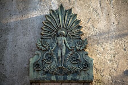 Detailed ancient stone relief of a male angel on a german cemetery in Berlinの写真素材