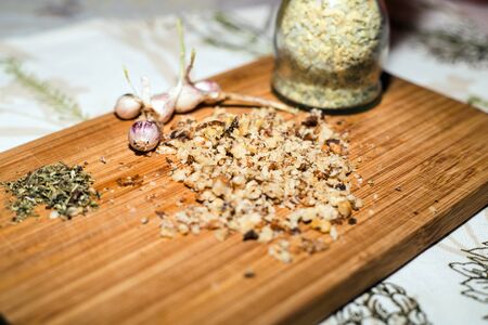 Spices and chopped walnuts on wooden boardの写真素材