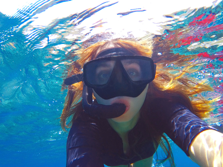 Beautiful woman under water before dive to coral reefの写真素材
