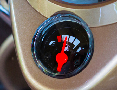 Fuel gauge on motorcycle dashboard. Round fuel gauge with red arrow. Fuel gauge show petrol run out....