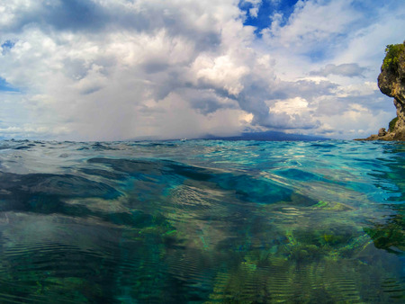 Marine landscape with transparent water and blue sky. Blue sea water look through. Double seaview...