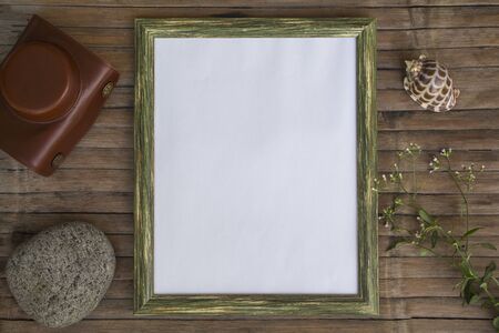 Vertical frame with white blank page photo background. Rustic wooden board backdrop with natural decor. Retro style flat lay with hipster camera bag. Shabby chic banner template with place for textの写真素材