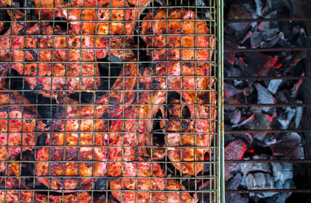 Grilled meat on coals closeup photo. Red meat barbecue cooking. Outdoor grill with pork ribs. Juicy meat food. Summer picnic banner template. Tasty pork BBQ. Brown pork chops baked on fireplace imageの写真素材