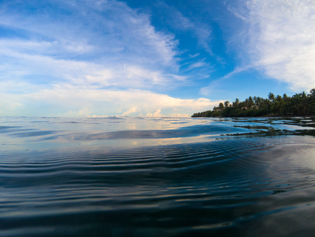 Seaside landscape with sea and sky. Tropical seashore. Still sea with rippled surface. Sunny sky reflection in sea. Sunset on beach. Exotic island shore view. Sea background. Tropic seaside vacationの写真素材