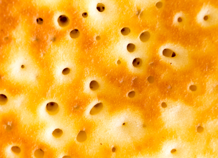 Pancake close-up photo. Baked pancake or bakery bubbled surface. Fried pancake texture. Abstract tasty menu background. Golden pancake top view. Baked bread closeup. Warm tasty crepe ready for eatingの写真素材