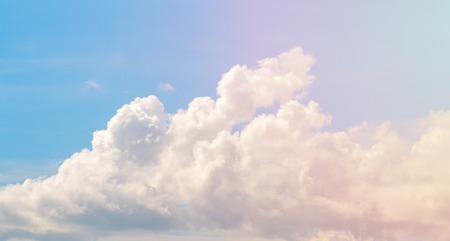 White cloud on blue sky. Cloudscape photo background. Romantic skyscape with cloud and pink sun flare. Stormy cloud on sunny sky. Climate or weather change. Moisture concept. Fluffy cloud closeupの写真素材