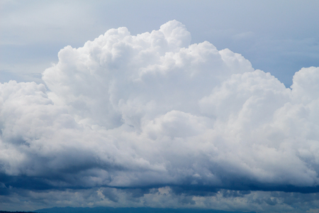 Fluffy cloudy sky background photo. White cloud closeup. Rainy clouds on blue sky. Daytime skyscape with cumulus. Tropical climate summer. Rain season weather. Pure clean ecology. Heaven conceptの写真素材