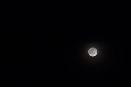 Full moon on dark night sky. Skyscape with moon phase in equator. Black and white night sky photo. Moon relief. Space light in darkness. Cosmic banner template. Earth natural satellite telescopic viewの写真素材