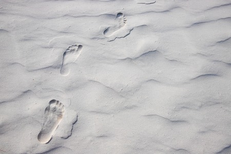 Foot marks on white sand beach. Barefoot walk marks.の写真素材