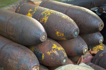 Medieval bombs with patina. Iron shell of cannon balls. Historical museum ammunition. Unused cannon balls pile. Stack of rustic cannon shells. Military object. Unexploding war missile of XIX centuryの写真素材