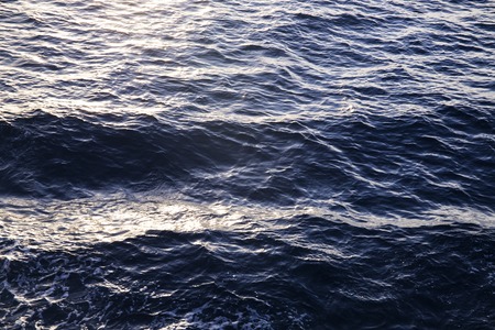 Sea water texture in sunrise light. Water background texture. Sea surface in sunset light. Breezy wavy seawater. Sea water texture. Deep blue ocean view. Fresh water of lake. Relaxing natural photoの写真素材