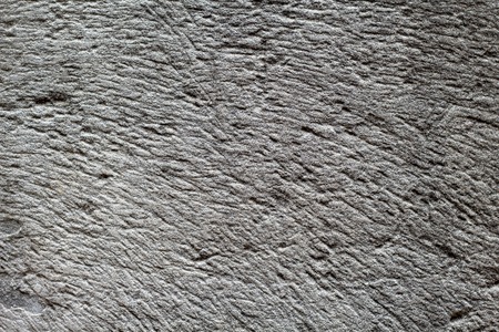 Rough grey stone texture photo. Ancient polished stone background. Weathered rock relief. Weathered sandstone surface closeup. Distressed stone texture. Natural floor material. Grungy rock formationの写真素材