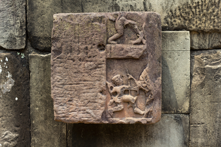 Ancient temple stone carved bas-relief in Angkor Wat. Weathered human figures bas-relief closeup. Angkor Wat temple architecture detail.の写真素材