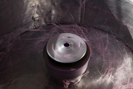 Pink cotton candy cooking machine closeup photo. Rotating cylinder of candy cotton floss machine....