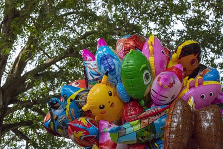 Dumaguete, the Philippines - 27 July 2018: colorful air balloons on green tree background. Colorful helium balloons with popular children movies character. Airballoon figures from animation moviesのeditorial素材