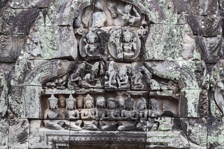 Stone carved bas-relief of Banteay Samre temple in Angkor Wat, Cambodia. Deity figure bas-relief. Khmer architecture heritage detail. Ancient building with stone carving art. Weathered sandstone decorの写真素材