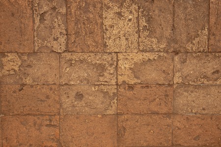 Solid brick floor. Orange bricks closeup. Weathered grungy brick floor photo background. Grunge texture of brickwork. Ancient building floor. Rough masonry with grit. Weathered old wall textureの写真素材