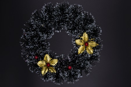 Christmas decorative wreath with golden floral top view on black background. Winter Holiday season backdrop. Red and golden Christmas decor flat lay. New Year banner template with text placeの写真素材