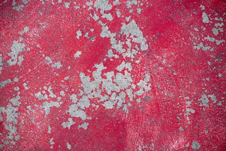 Weathered red plaster on asphalt road. Painted wall grungy texture photo for background. Red paint...