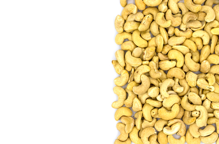 Cashew nut half on white background, top view photo with text place. Scattered nut snack. Organic food rustic banner template. Natural nut flat lay. White cashew heap flat lay. Nut package designの写真素材