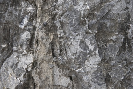 Cracked stone texture background. Distressed natural surface. Ecologic design template. Volcanic rock cracked surface. Weathered material background. Grunge durable texture. Grey rock structure photoの写真素材