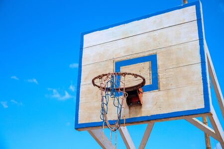 Basketball backboard on blue sky background. Rustic outdoor sport equipment. Summer outdoor activity...
