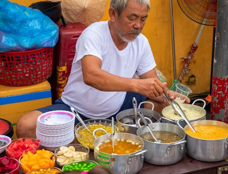 Hoi An, Vietnam - 28 Jul 2019: local eatery with food seller and soup bowl. Vietnamese street food....