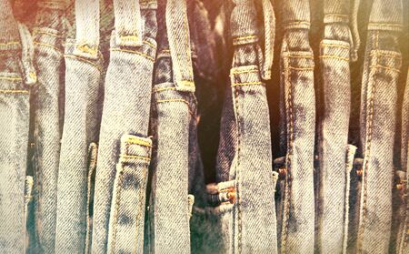 Worn Jeans in wardrobe or on store hanger. Vintage jeans retro style photo. Streetwear on hanger in...