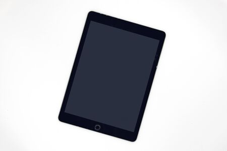 Black screen pad on white background, top view photo of personal gadget. Tablet app mockup. Digital communication on screen. Mobile device on clean work desk banner template. Application on padの写真素材