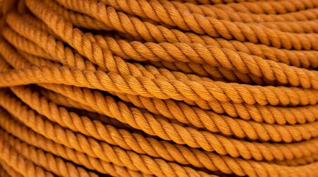 Yellow cord background, close-up photo. Braided rope texture. Ship or rock climbing tackle. Natural...