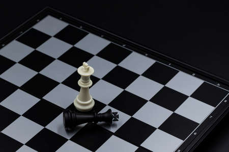 Chess game finish on chessboard. Victorious and defeated king figure. Chess figurine order....