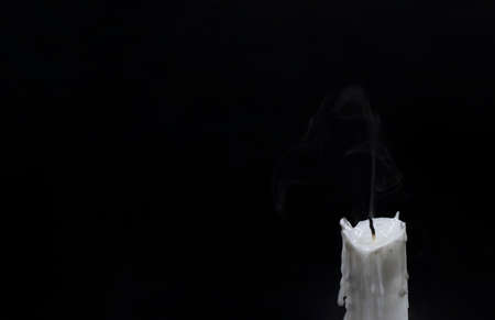 Extinguished candle with smoke. White candle wick blow out. Memory photo. One candle with fire on...