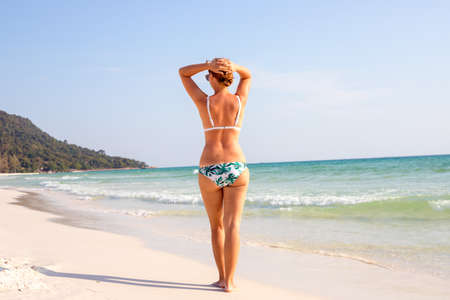 Young woman on white beach. Tanned tourist on empty tropical beach.の写真素材