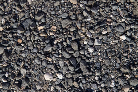 Grey gravel texture. Rustic road surface top view. Big gravel closeup photo for background. Rough gray stone road template. Broken stone texture. Road construction material. Construction site conceptの写真素材