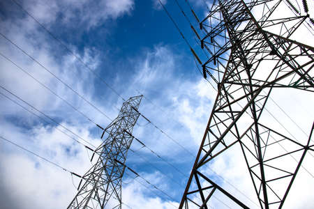 Electric tower and wires on blue sky. Telecommunication and internet provider equipment. Communication tower with wire line. Electrical pylon view from ground. Transmission tower skyscapeの写真素材