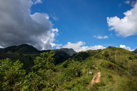 Green mountain range and walking path under blue sky landscape. Rural land scenery. Summer travel hiking in green hills. Untouched nature parkland. Volcanic island reliefの写真素材