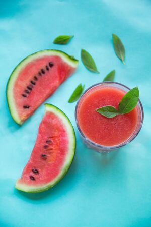 Fresh Watermelon Juice, Smoothie on Blue Background with Watermelon Slice and Mint Leaves, Top View. Concept Shot.の写真素材