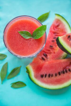 Fresh Watermelon Juice, Smoothie on Blue Background with Watermelon Slice and Mint Leaves, Top View.の写真素材
