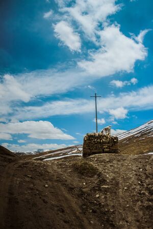Cross against a blue sky in Spiti Valley, Himachal Pradesh, India. Picturesque and serene landscape of a popular tourist destination in India for Solo Travelers and Backpackers. Mountain and clouds.の写真素材