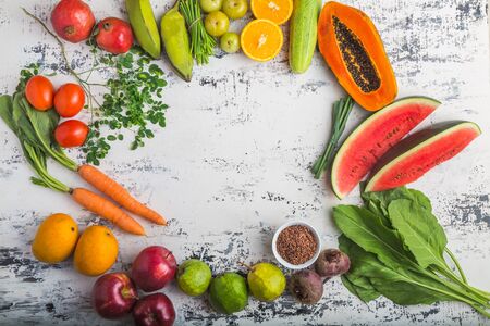 Various fruits and vegetables (Mango, Apple, Orange, Tangerine, Tomato, Carrot, Water Melon, Spinach, Pomegranate, Papaya, Wheatgrass) on a white background, top view, creative flat layout. Concept of healthy eating, food background. A frame of fruits and vegetables with space for text. Food Concept Shot.の写真素材