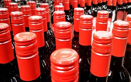 Rows of glass bottles, red caps, closeupの写真素材