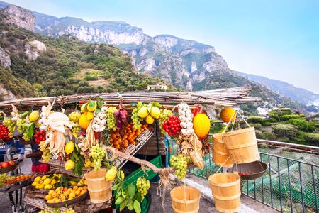 A fruit shop vith different fruits, a beautiful landscape as background