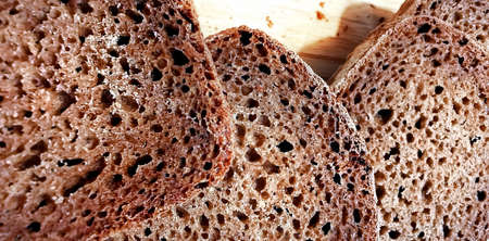Three tasty pieces of bread, closely on a wooden boardの写真素材