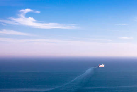 A big white ship, small, one, calm water, blue sky with white clouds, wide empty spaceの写真素材