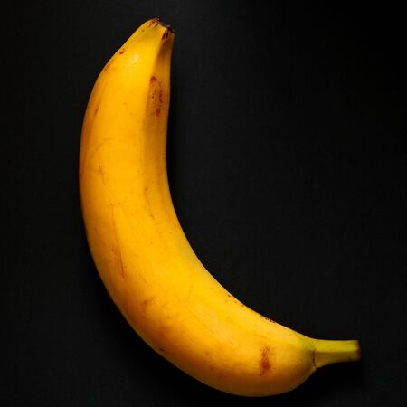 one ripe banana. Dark background. top viewの写真素材