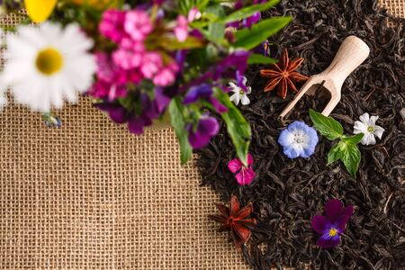dry tea leaves with flowers on rustic background. Top view.の写真素材