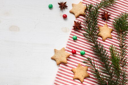 Christmas or new year gingerbread cookies with colour candies with spruce twings on white background